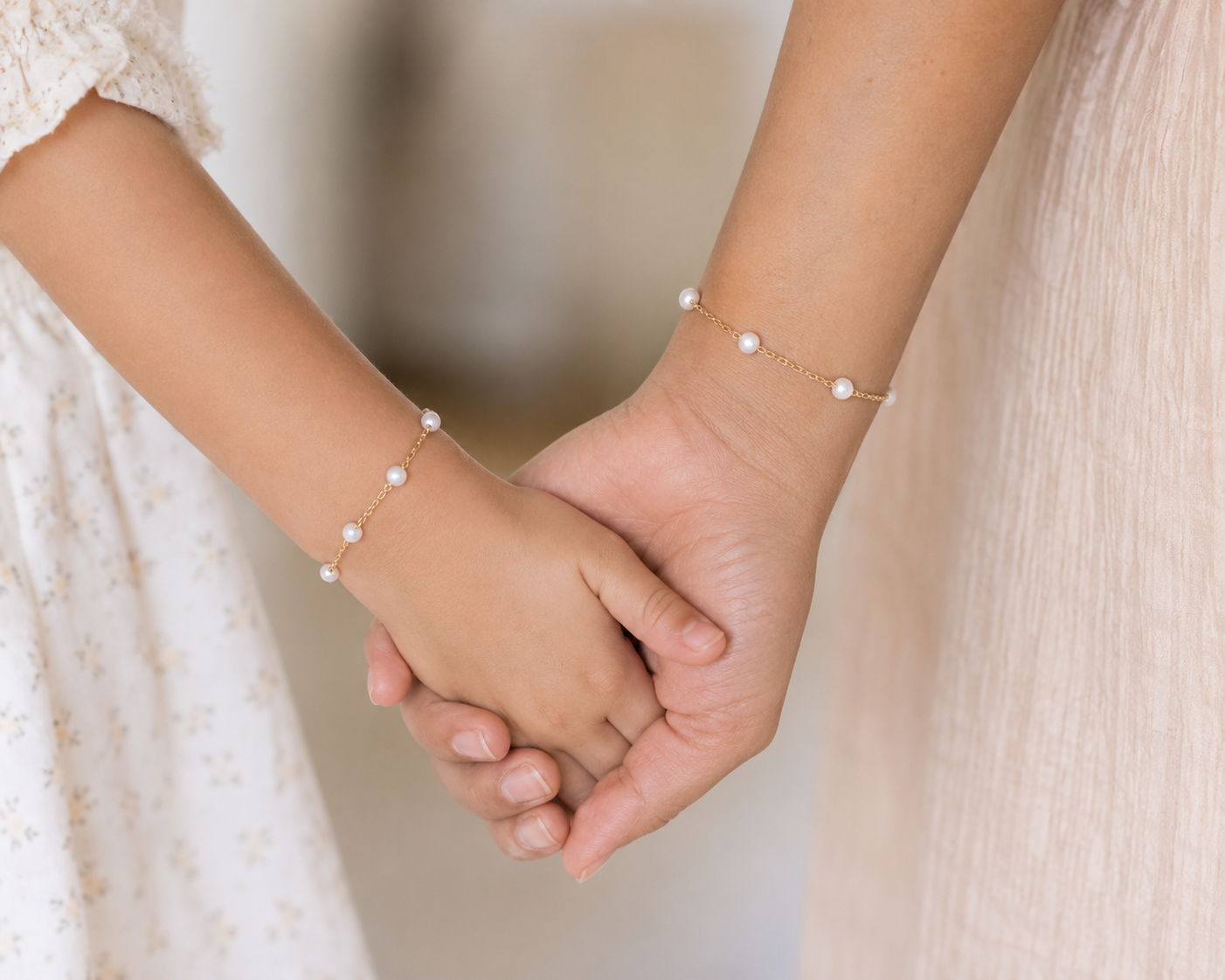Mother and daughter wearing matching pearl station bracelets